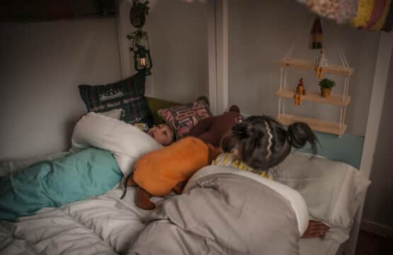 連結されたベッドには子供二人が並んで横になり、周りにはランプや吊り棚に囲まれた洋室3です。