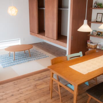 ダイニングテーブルの上には白いクロスが敷かれています。四角い畳が使用された和室には木製テーブルが置かれています。