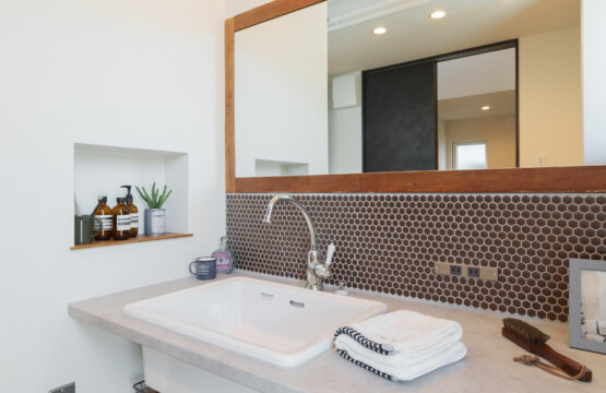 オールドチーク材枠の大きな鏡、モルタル調のカウンターに大きな洗面ボウル、レトロな6角形のモザイクタイルが施された洗面化粧台です。